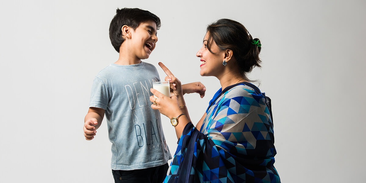 Mother making her son drink milk