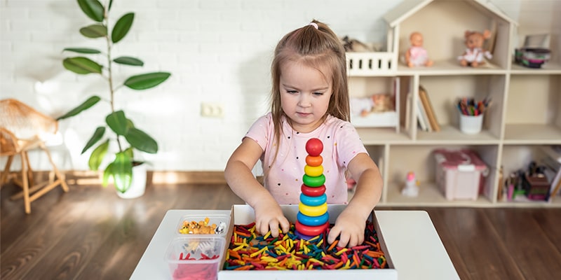 little girl playing wooden pyramid