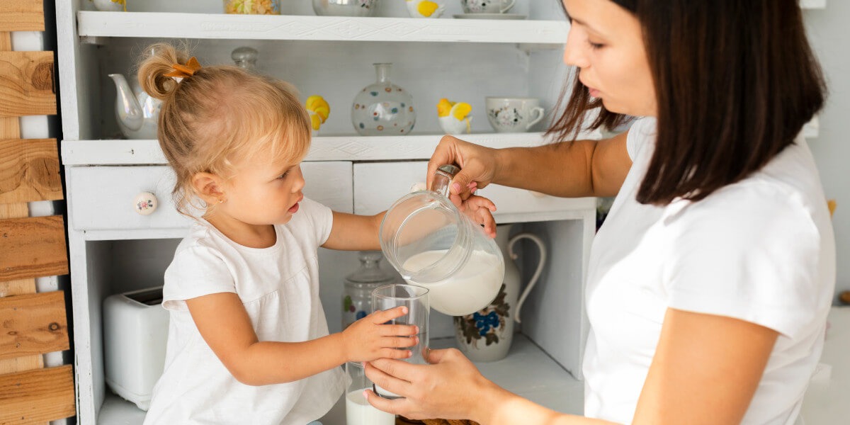 Mother pouring milk her daughter