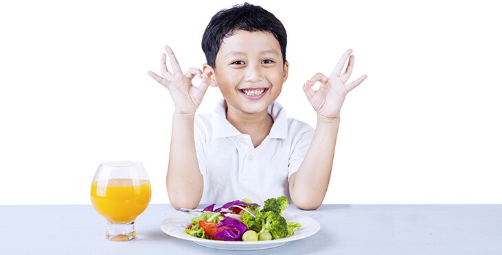 Kid with juice and veggies