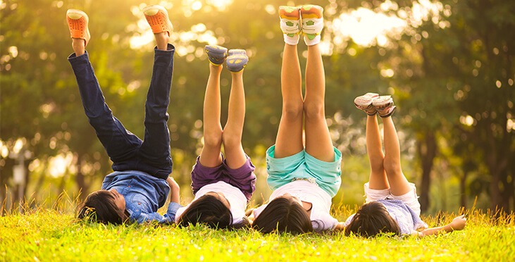 Kids lying on the ground with legs in the air