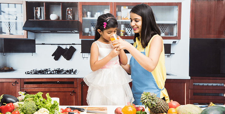 Woman feeding juice to her daughter