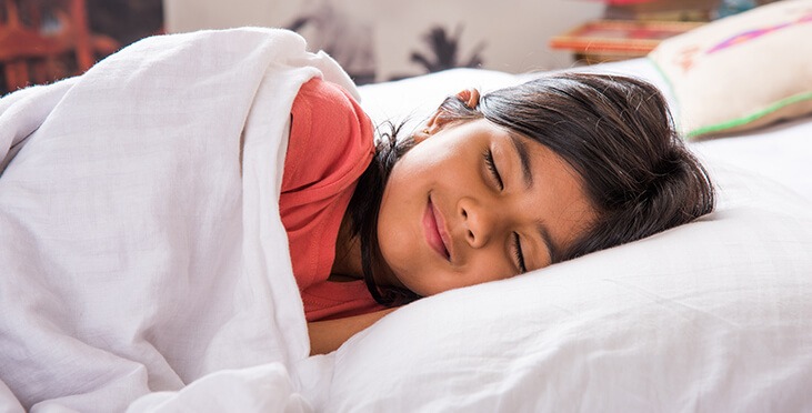 Happy little girl sleep in bed